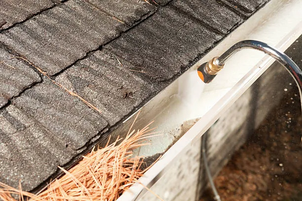 Gutter being flushed clean of leaves and debris